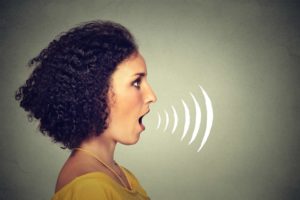 Woman singing with sound waves coming out of her mouth