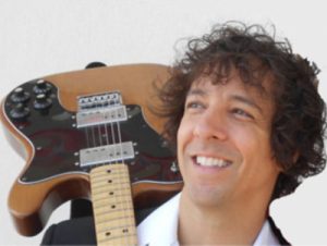 Voice teacher Daniel Formica holding a guitar