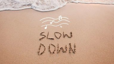 Slow Down written in sand
