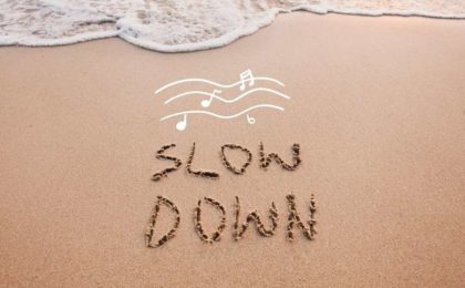Slow Down written in sand