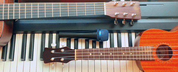 photo of a guitar, ukulele, keyboard, and microphone