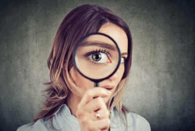 photo of a woman looking through a magnifying glass