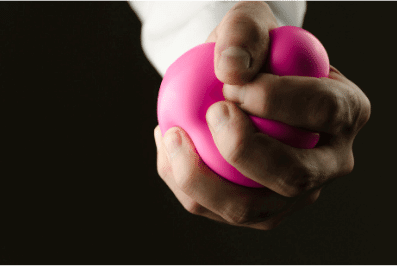photo of a hand tightly gripping a stress ball
