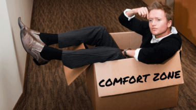 photo of a man sitting in a cardboard box labelled "comfort zone"
