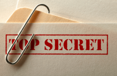 photo of the words top secret stamped onto the corner of a manila folder with a paper clip