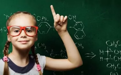 Smart looking kid in front of a chalkboard