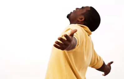 photo of a man looking up with his arms out