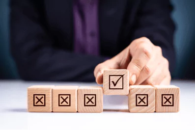 photo of a person picking up a tile with a check mark from a line of tiles with x marks