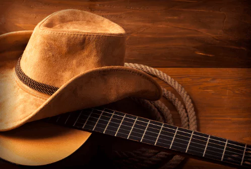 an acoustic guitar with a cowboy hat