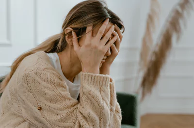 doubts photo of a woman sitting with her hands covering her face