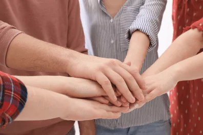 hands in photo of hands of team members placed on top of each other