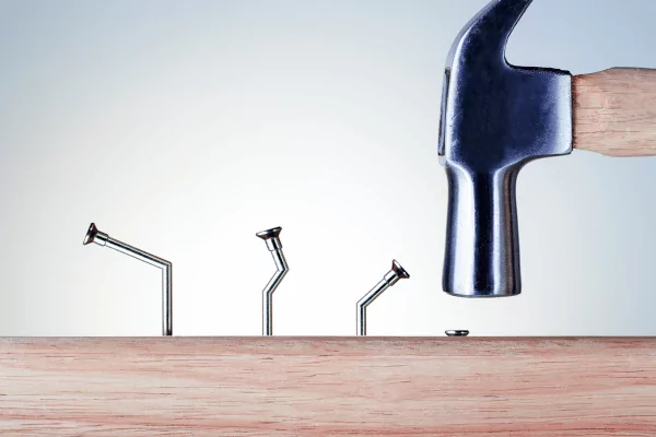 learn from mistakes photo of a hammer cleanly hammering a nail on the fourth attempt