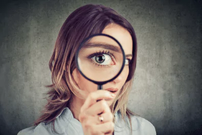 magnifying glass photo of a woman looking through a magnifying glass
