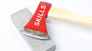 photo of an axe with the word skills printed on it laying on top of a whetstone
