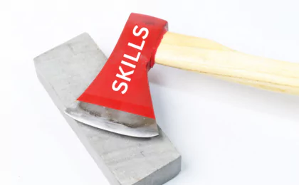 photo of an axe with the word skills printed on it laying on top of a whetstone