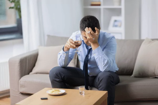 photo of a stressed man smoking and drinking