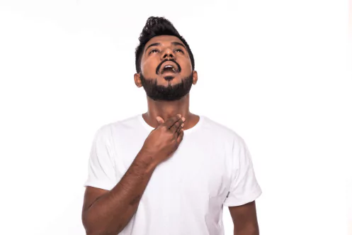 photo of a man trying to make sound with a hand on his throat